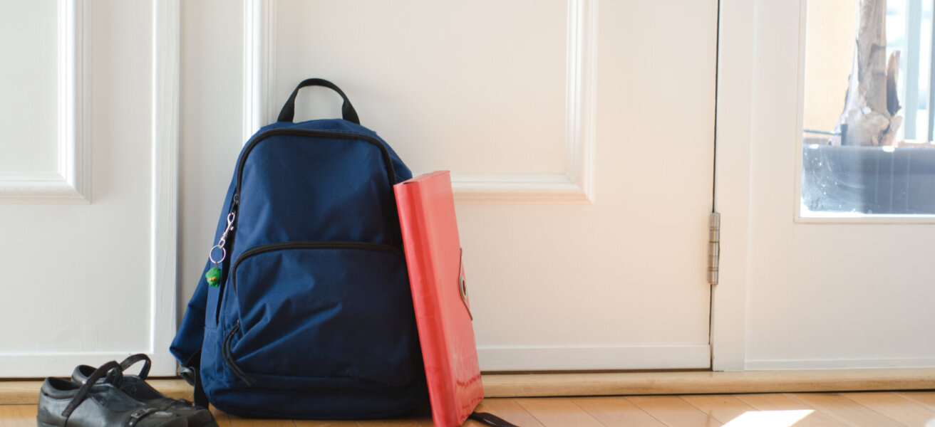 Back to school or ready for school concept with school bag and shoes by front door