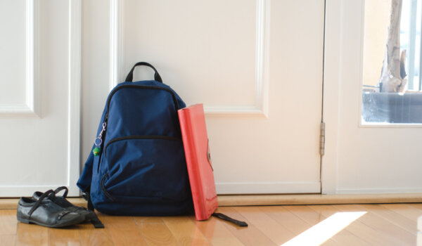 Back to school or ready for school concept with school bag and shoes by front door