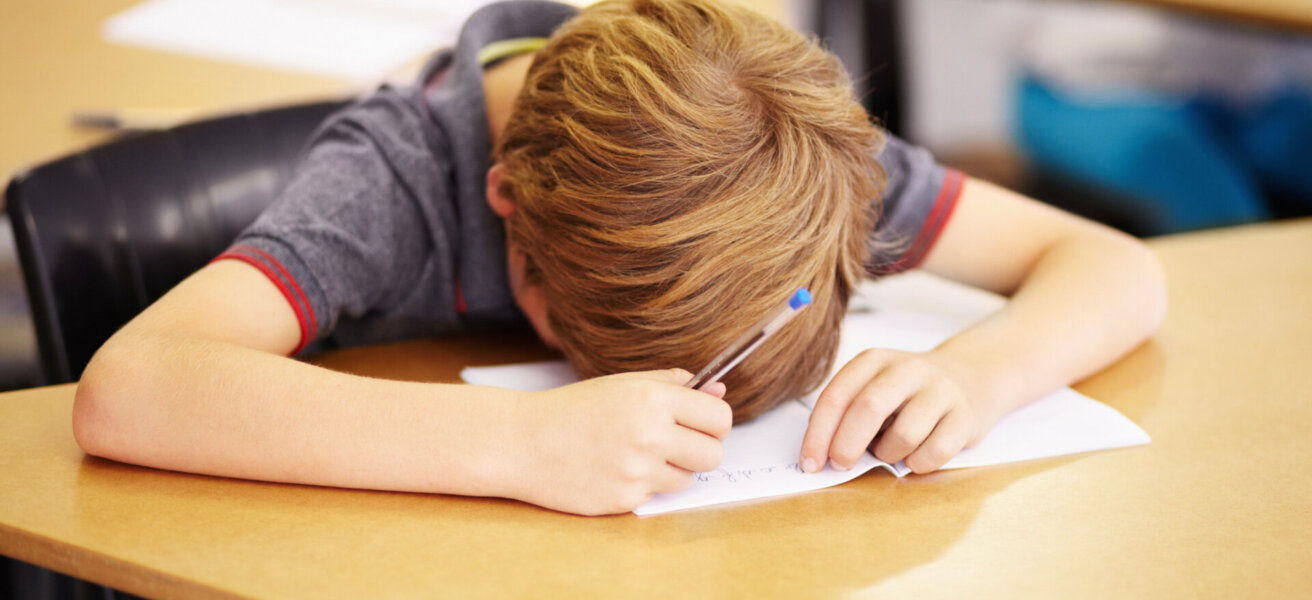 Sleeping, bored and tired with boy in classroom for learning, education and knowledge. Stress, anxiety or confused with male student at desk in school adhd for exhausted, autism problem or frustrated