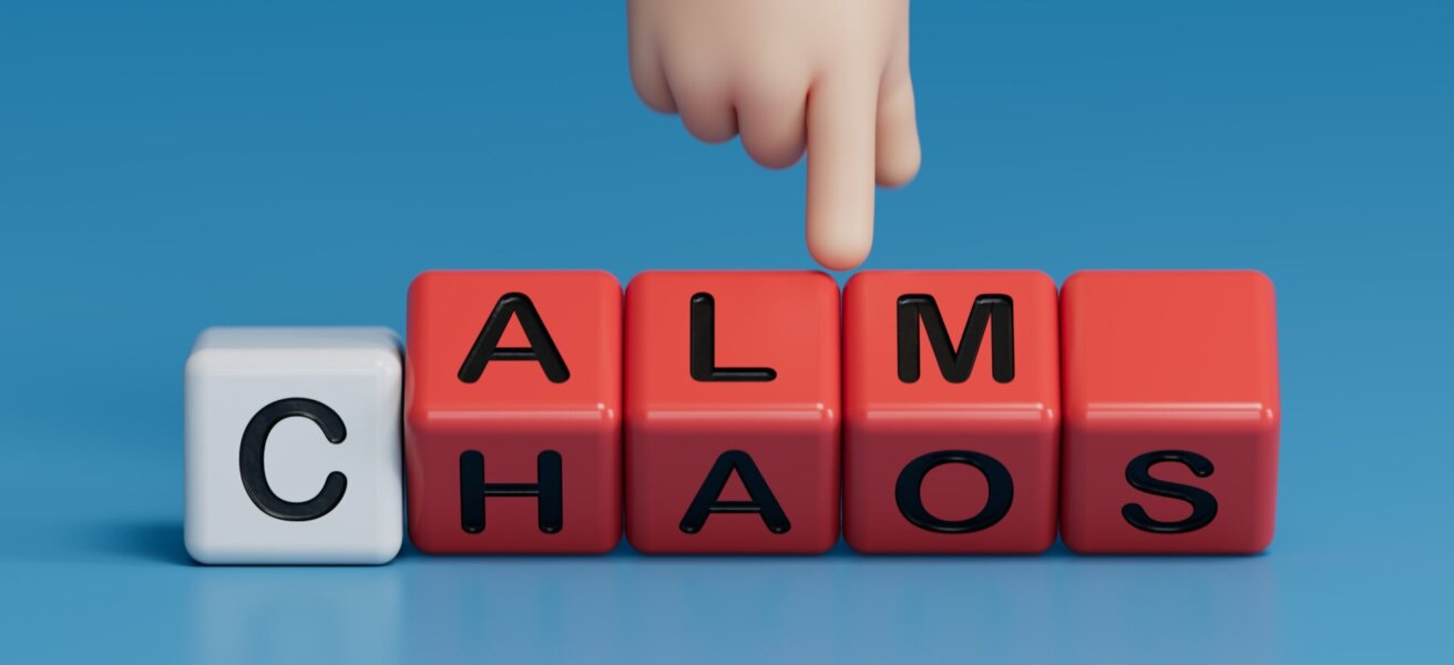 Calm vs chaos symbol. Businessman hand turns wooden cubes and changes word Chaos to Calm.Business and Calm vs chaos concept. Copy space.3D rendering on blue background.