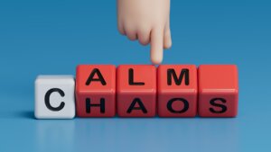 Calm vs chaos symbol. Businessman hand turns wooden cubes and changes word Chaos to Calm.Business and Calm vs chaos concept. Copy space.3D rendering on blue background.