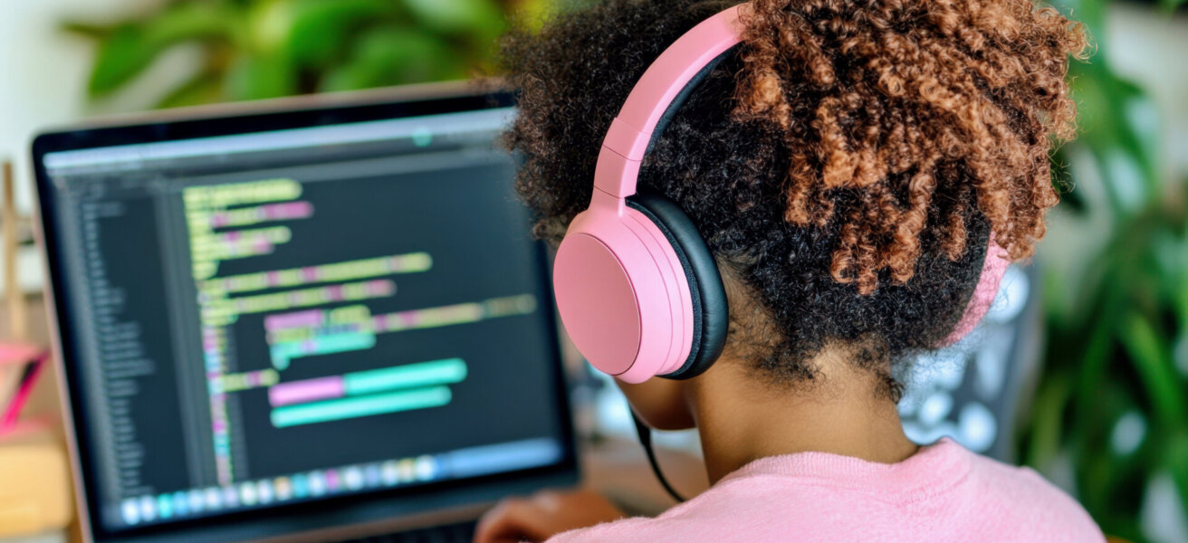 Teenage girl sits at laptop and coding. Black teen girl uses AI powered tool, interactive lessons. Online education, technology, artificial intelligence, science concept